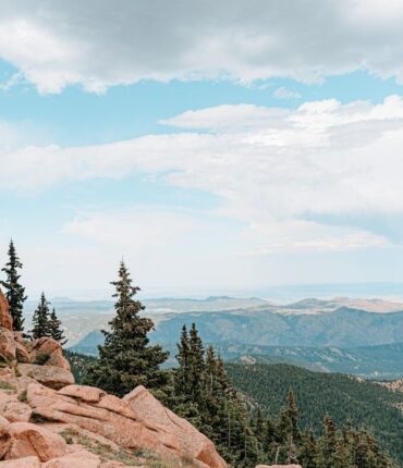 Rocky Colorado mountain overlook with trees and distant ridgelines
